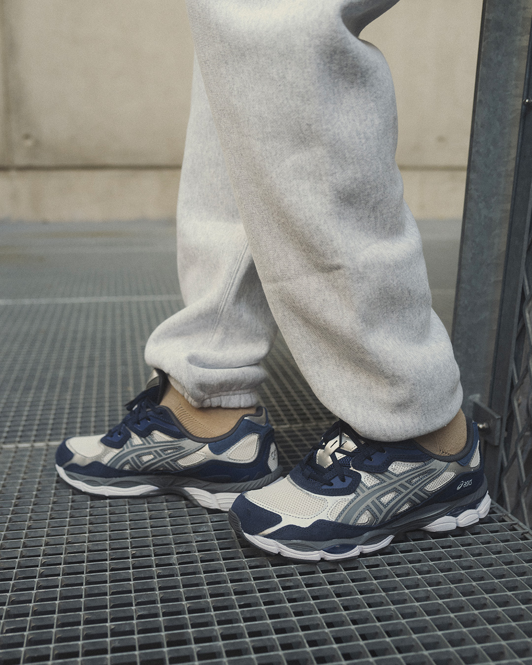 ASICS Gel-NYC navy usado no pé sobre grade metálica
